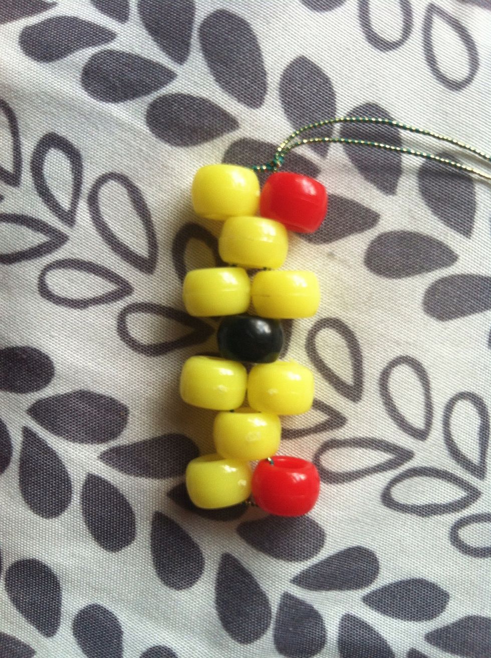 Follow that order of opening and closing your strings and adding the beads, it should look like this. Once you finish, tie a knot with both strings.
