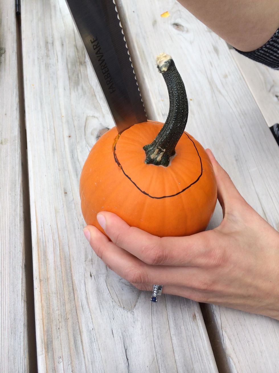Following the outlines, carve the tops off of each of the small pumpkins.