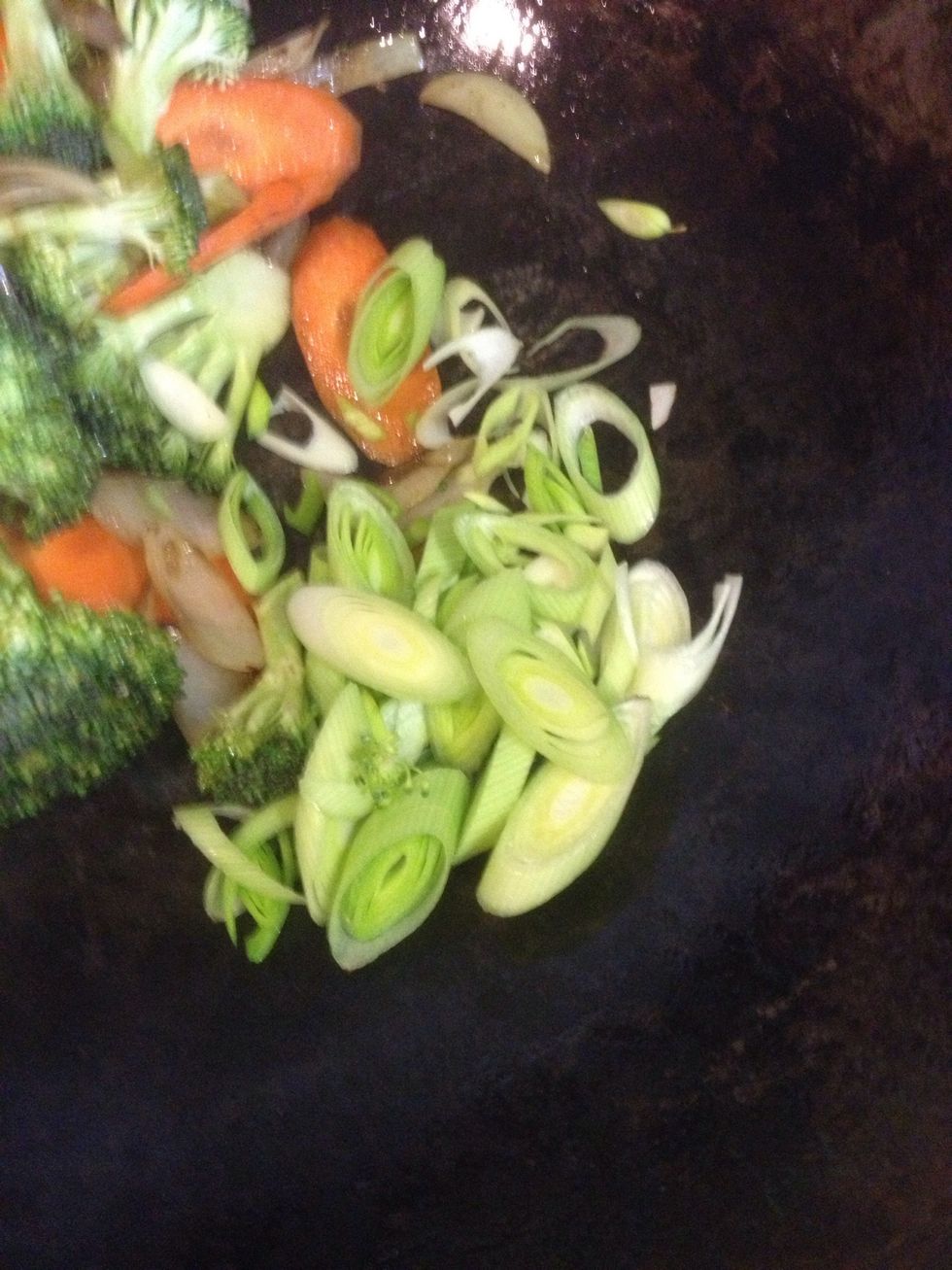 For a change in texture, finely chop a leek and add it to the wok.