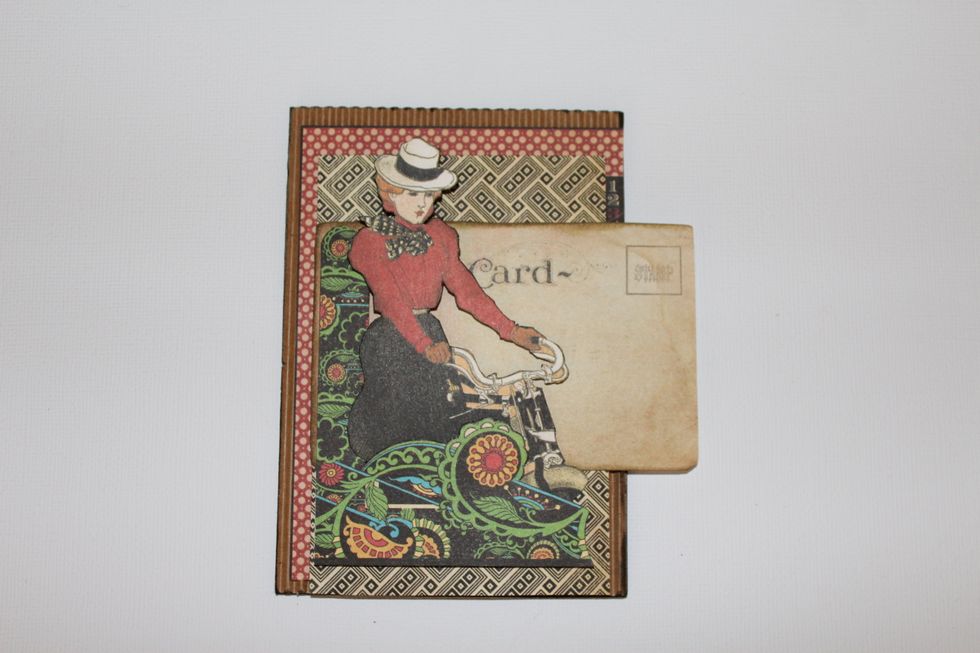 For add volume, attach with 3D foam adhesive the central figure to the cover. Add some decorative paper.