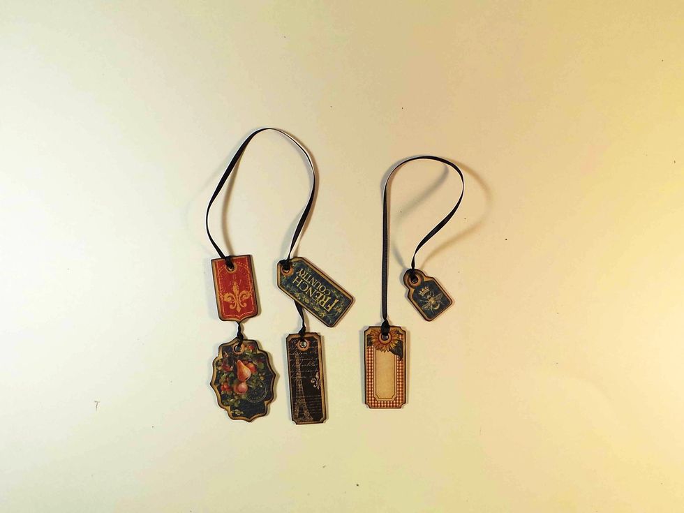 For Front Cover, cut ribbon approximately 20" long and add two tags to each end, spaced as desired. For Back Cover, cut ribbon approximately 15" long and add 1 tag to each end.