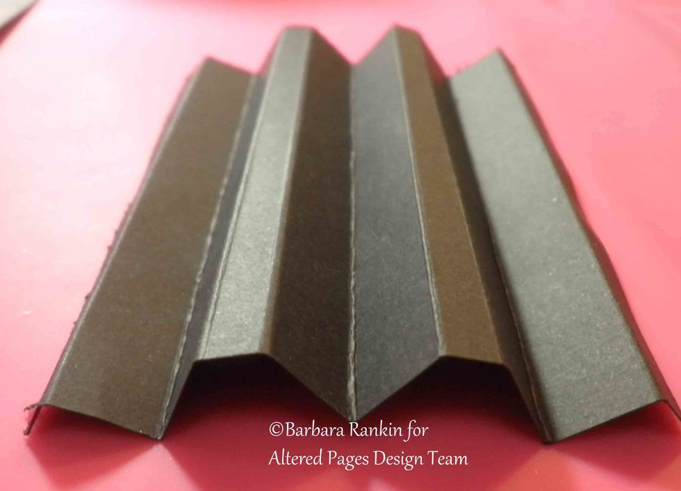 For page hinges, cut two pieces of black cs to 4-\u00bd x 4". Score along 4" side at \u00bc", \u00be", 1-\u00bc", 1-\u00bd", 2", 2-\u00bd", 2-\u00be", 3-\u00bc", 3-\u00be". Accordion fold so both your hinges look like this.