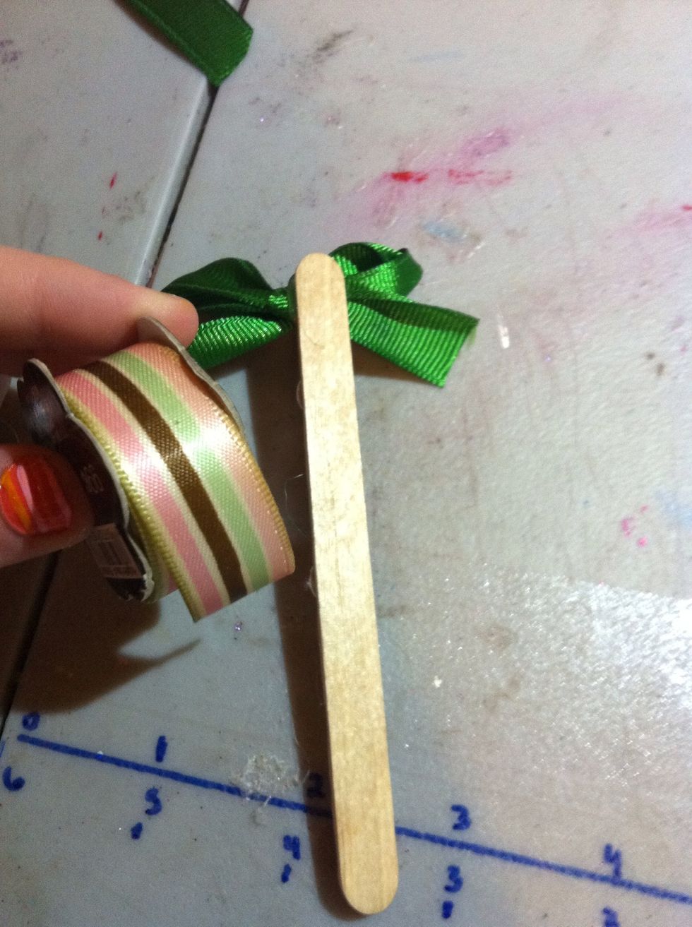 For the back, you can glue ribbon on it to make it prettier. I'm using striped ribbon in case I have to make it thinner to cover the stick.