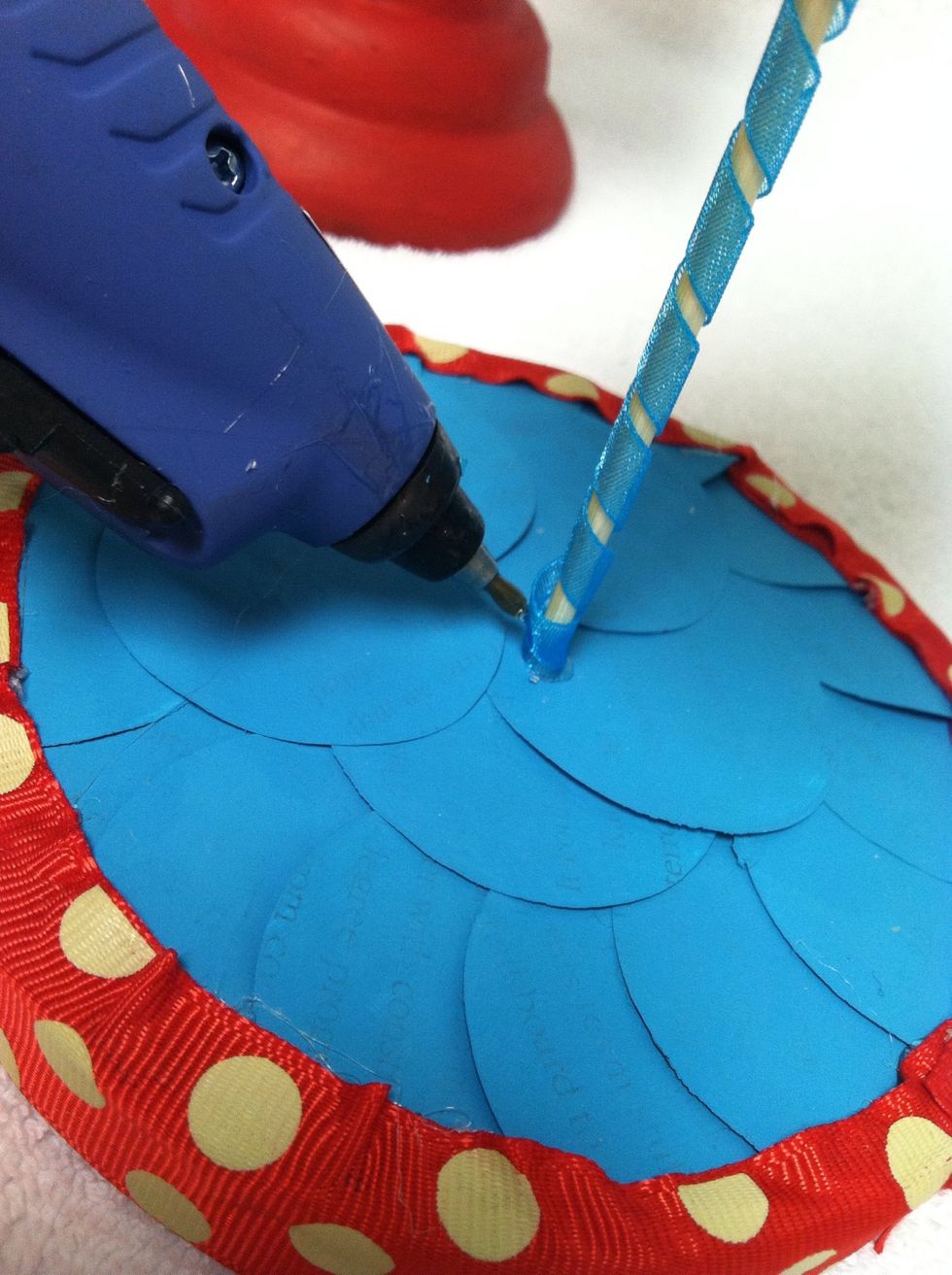 For the base, cover the top with one layer of circles in the same scallop as the tree. I inserted a kabob skewer through the bottom of the cone, hot glued it, then repeated the process on the base.