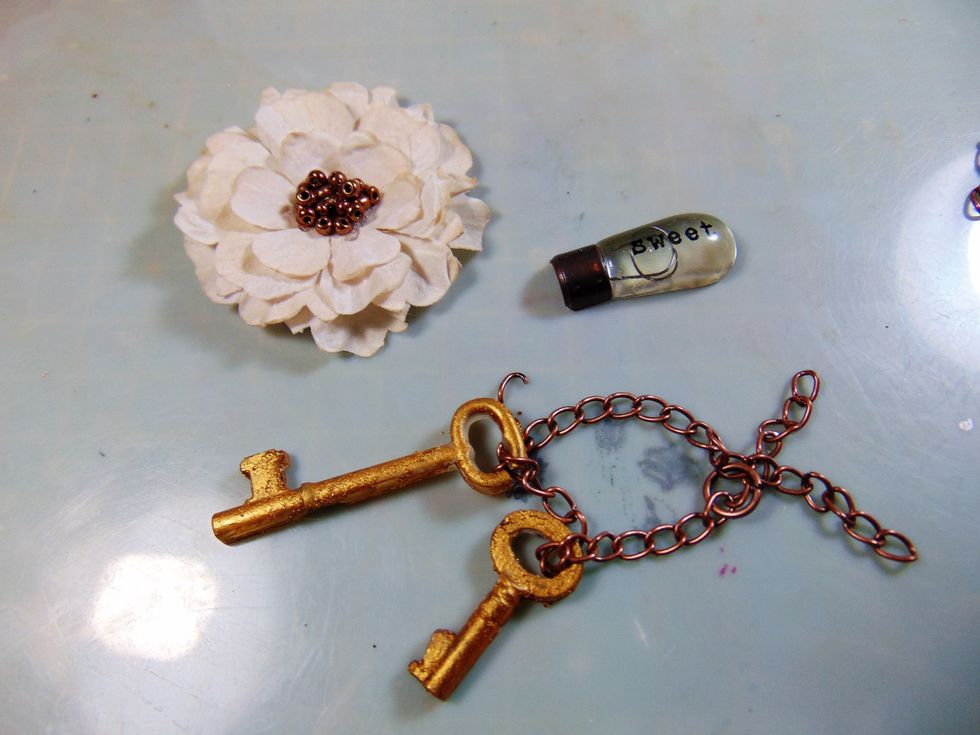 For the door I used these embellishments. The keys are made from Ice Resin in MS moulds and then covered with Inka Gold and strung on some copper chain.