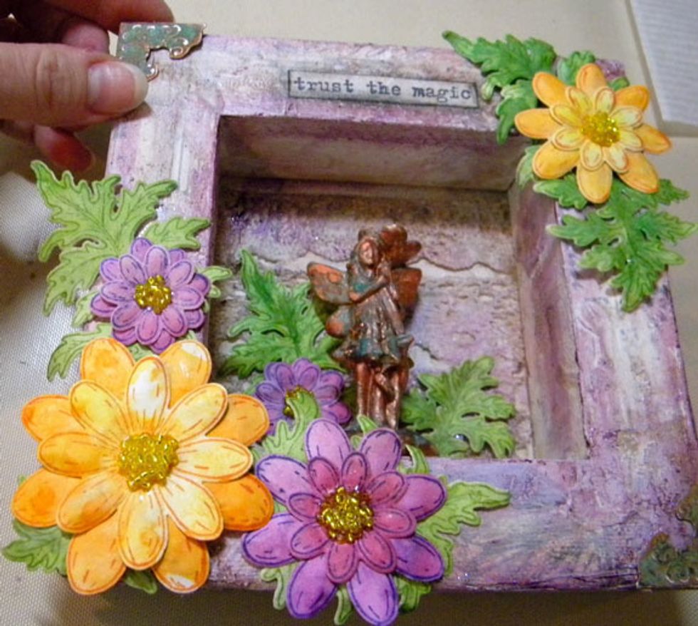 For the final touches I added metal corner embellishments and the stamped phrase. I added shadows around the words using a black Pitt pen. See below for more detailed photos.