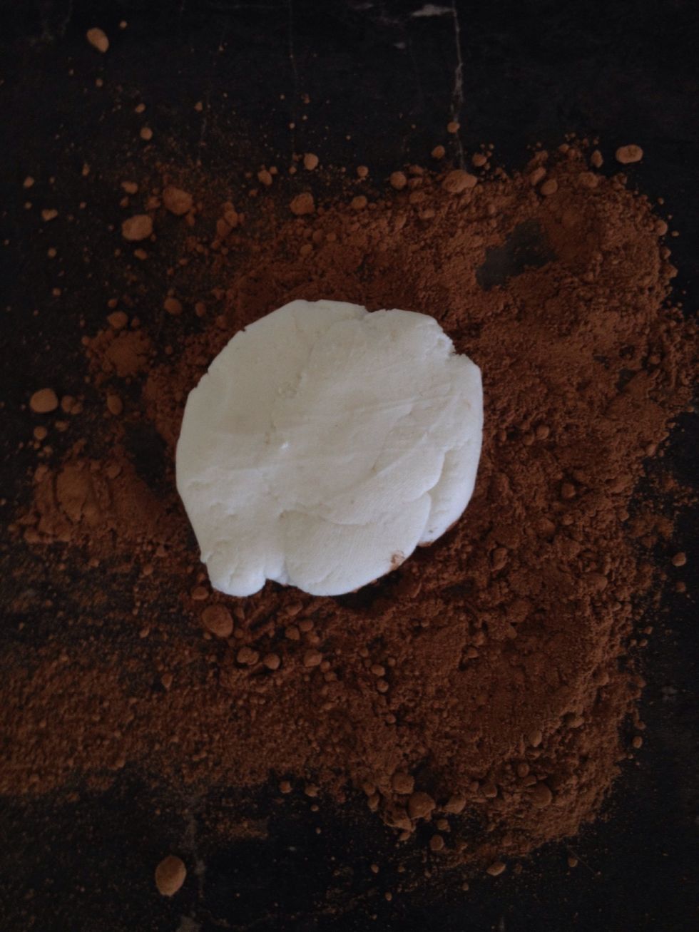 For the fourth cupcake, sprinkle some cocoa powder on the bench surface. Knead your fondant on the cocoa powder to make it squishy and to give it a brown colour.
