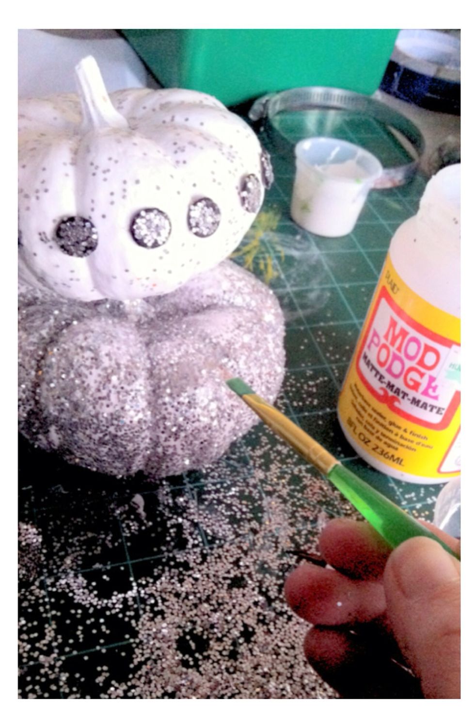 For the glitter, paint the entire pumpkin in Mod Podge then sprinkle glitter and let dry. Once dry, apply another coat of Mod Podge to seal the glitter.