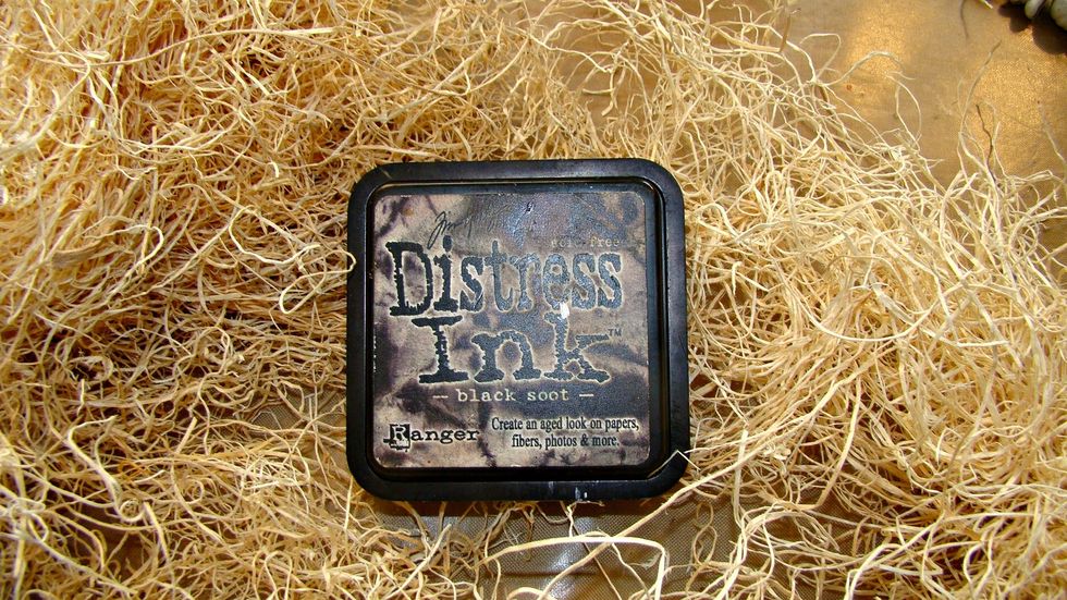 For the inside filler take your Distress Ink and swipe this over your filler for an aged look, using a wooden dowel, start stuffing your bottle till half full with filler.