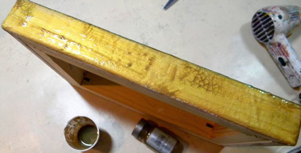 For the sides of the canvas, paint a layer of gesso. When dry, add a few coats of Gold Metal Effects, drying between coats. Add crackle paste, then dry. Lastly, add Chocolate Sorbet and wipe off.