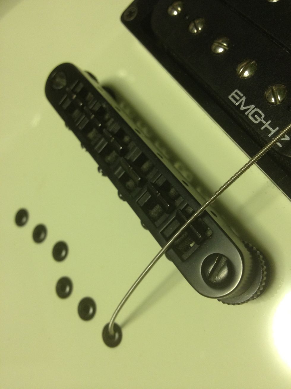 For the string thru, push the string through the hole and ensure that it goes over the bridge 'notch' correctly