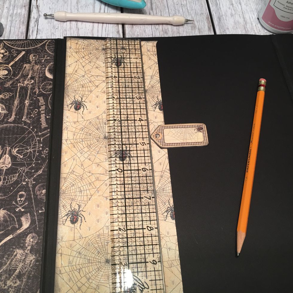 For the swing closure, select a chipboard piece.  Line up the patterned paper to the first page.  (Do not glue down) Place the chipboard piece centered from top to bottom and mark with a pencil.