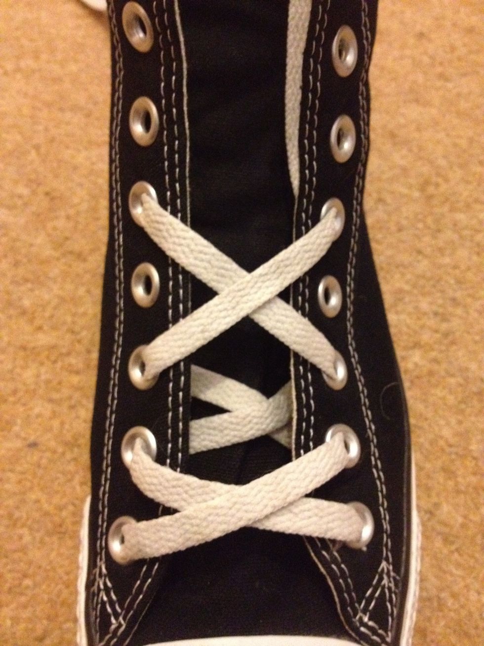 For the third kiss, cross the laces (again), and thread them over the sneaker and back in through the fifth eyelets.