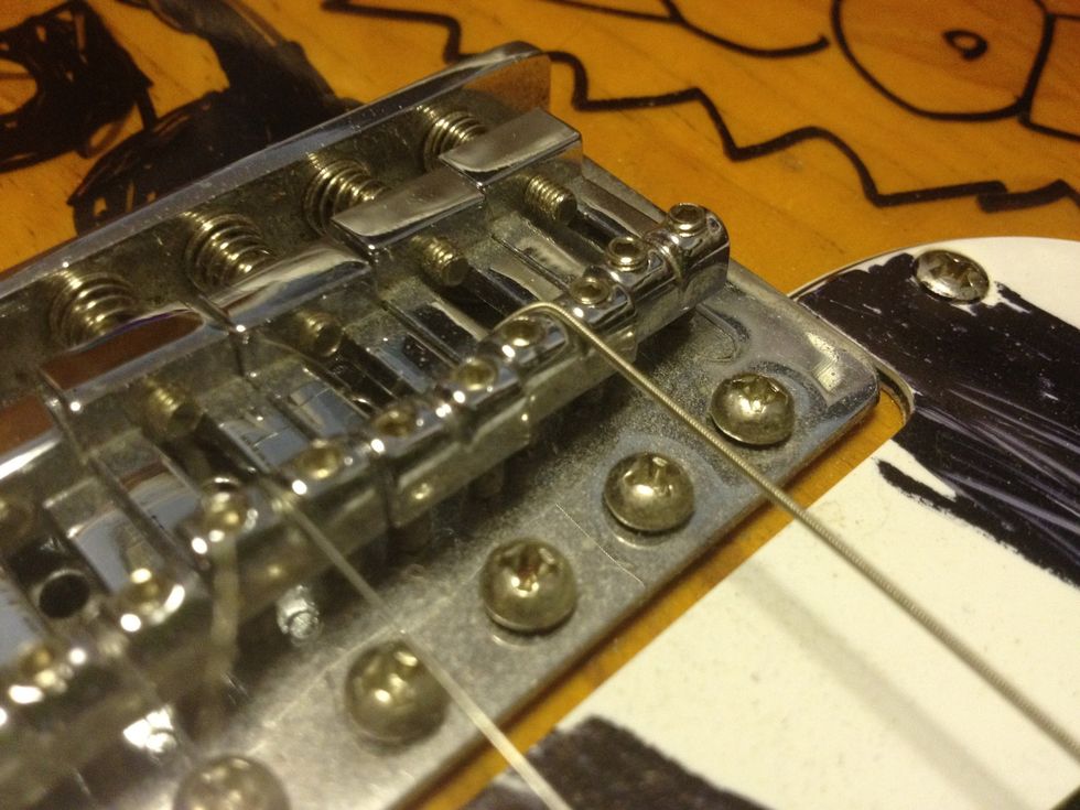 For the 'Top load' guitars, push the string through the back, and ensure it is placed within the metal notch