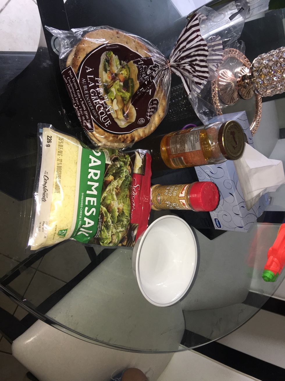 For this snack you will need whole wheat pita bread, canola oil, garlic powder, cumin, salt and grated parmesan cheese, and a bowl to mix ingredients