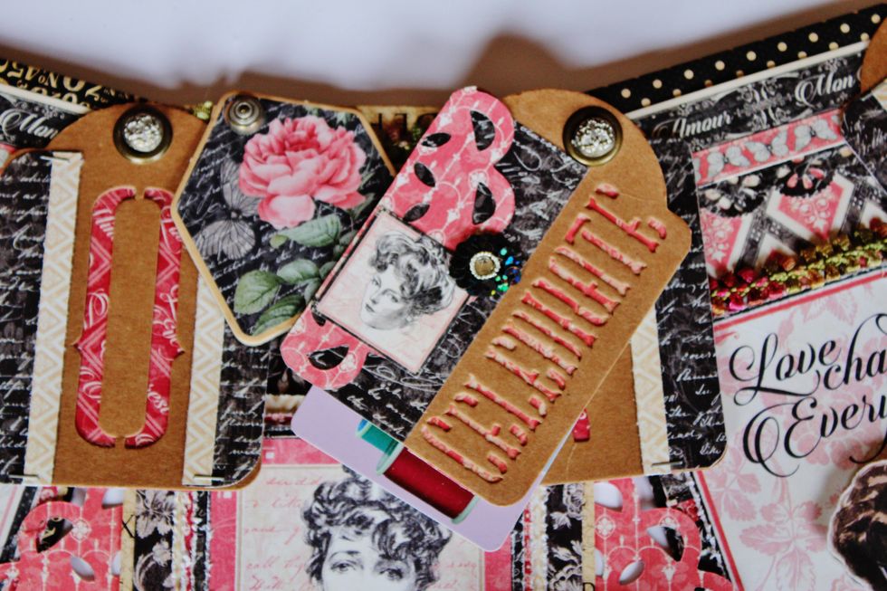 Form a pocket using the journal pieces that have been distressed. I hid a small gift tag inside that also has been decorated with pattern paper and a small brad.