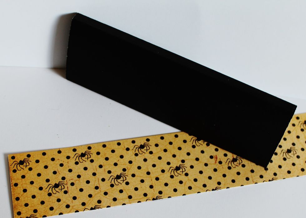 Form box holder with black card stock to fit around candy bar. Adhere pattern paper to formed box holder.