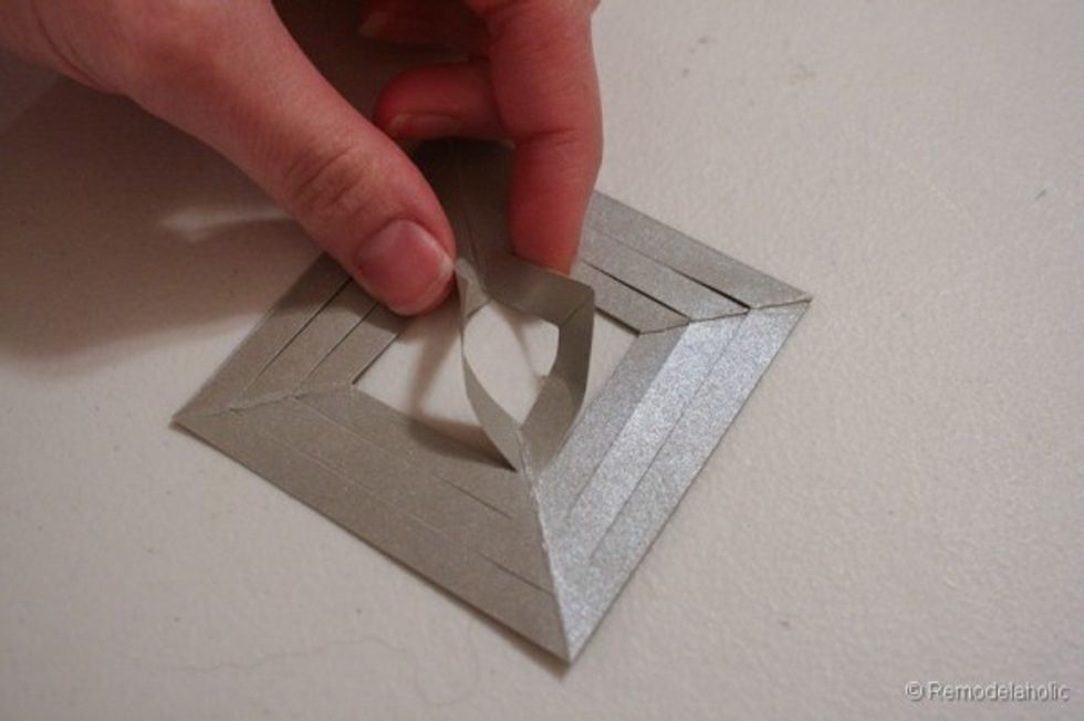 Forth, fold up the centre pieces and glue them together at the top. Do the same thing for the third square from the middle.