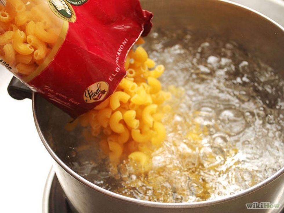 Forth, put the mac and cheese noodles and dump them in and stir with the spoon.