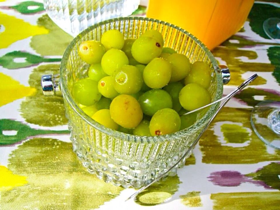 Freeze the grapes the night before and use them as ice. This way it'll not delude the drinks and it's a great snack on a hot summer day