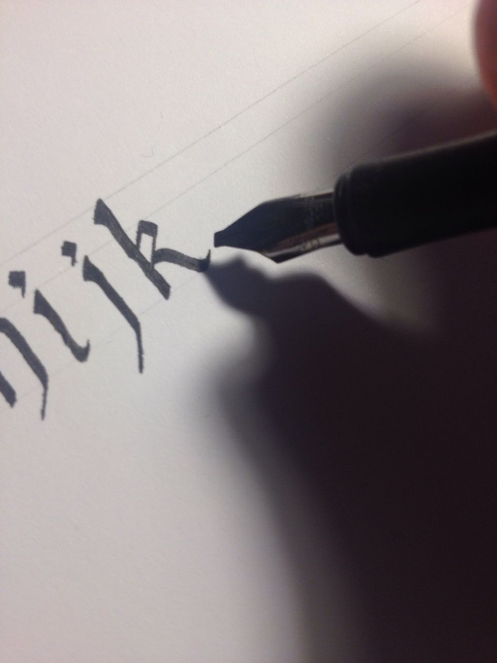 From here you can do several things; the second leg of "k" can be an elongated "j" shape, a straight thick line with an embellished foot, or, in this case, a simple wavy downstroke, thin on both ends.