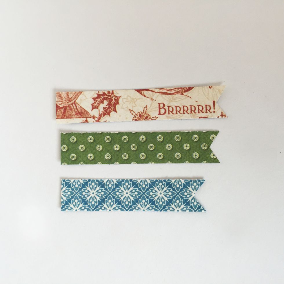 From January Collective (side B), cut piece 2 1/2\u201d x 1/2\u201d. From December Montage (side B), cut piece 2 /4\u201d x 1/2\u201d. Find the piece from step 1. Cut a triangle from bottom of each to create pennants.