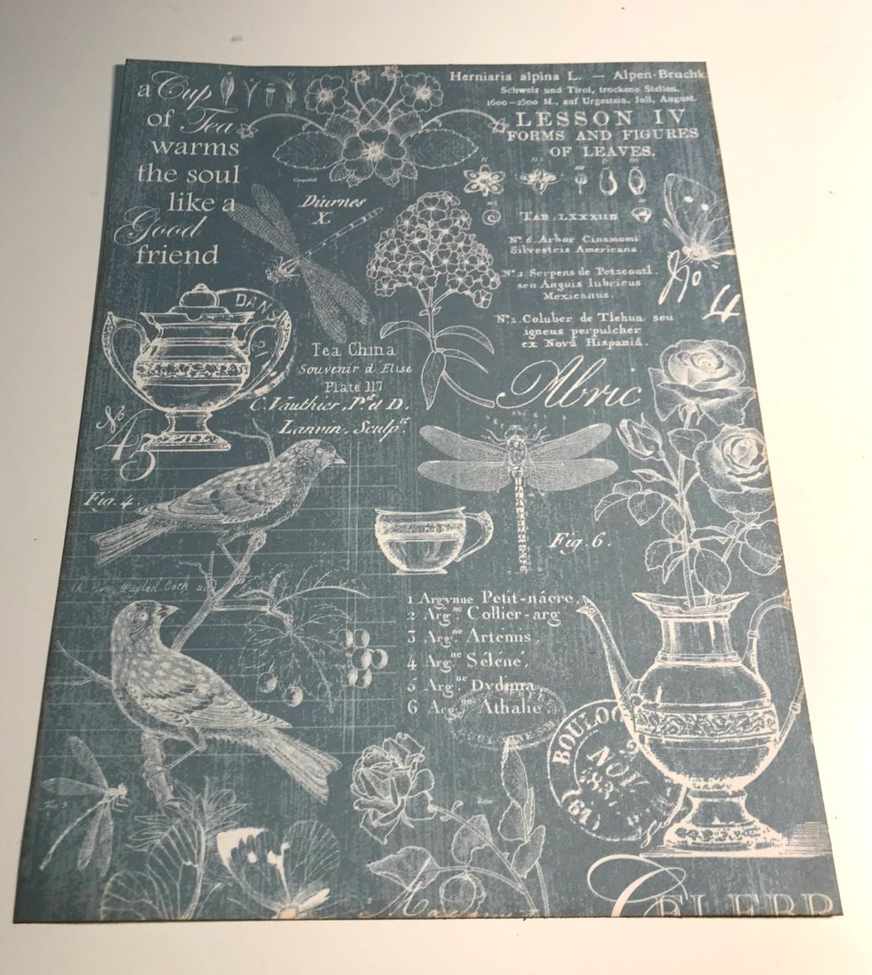 From the blue with white writing paper, cut a piece that measures 7" x 9 1/2". Ink the edges of the paper using Vintage Photo Distress Ink.