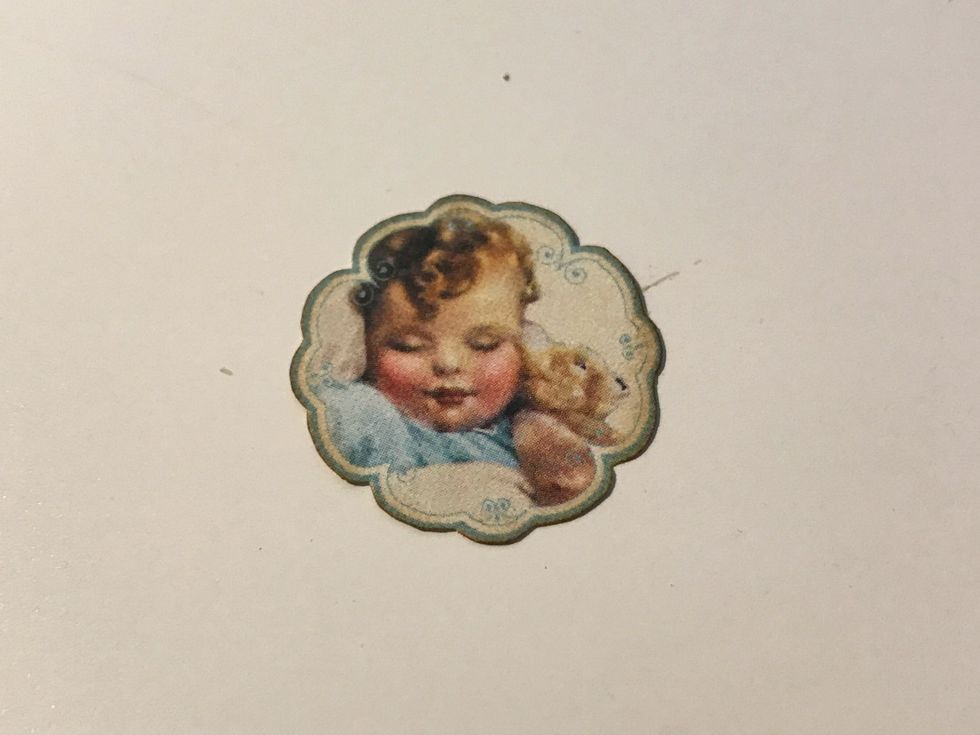 From the border paper, fussy cut the baby with teddy bear out. Ink the edges of the image using Vintage Photo Distress Ink and a blending tool with foam.