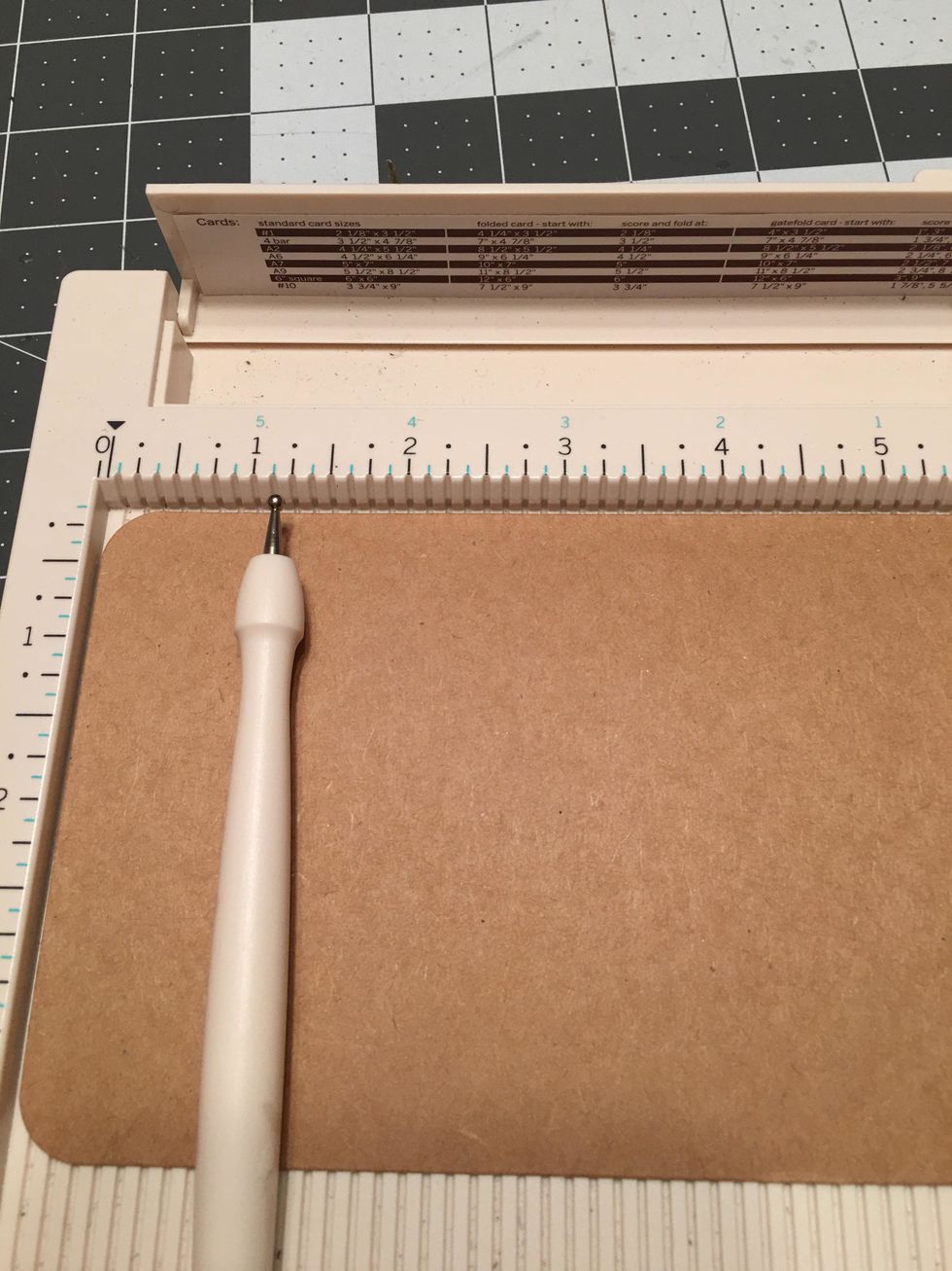 From the bottom rounded edge of the large kraft tag, score at 1.25 inches.