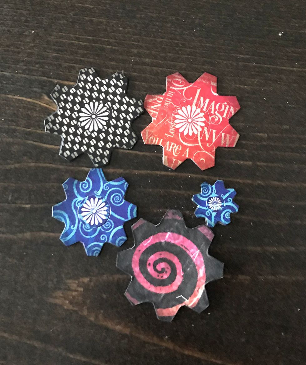 From the cardstock sticker sheet, you'll need to adhere the four flowers to scrap patterned paper. Fussy cut out. Trace one flower on same scrap paper. Cut out. Ink edges with black ink.