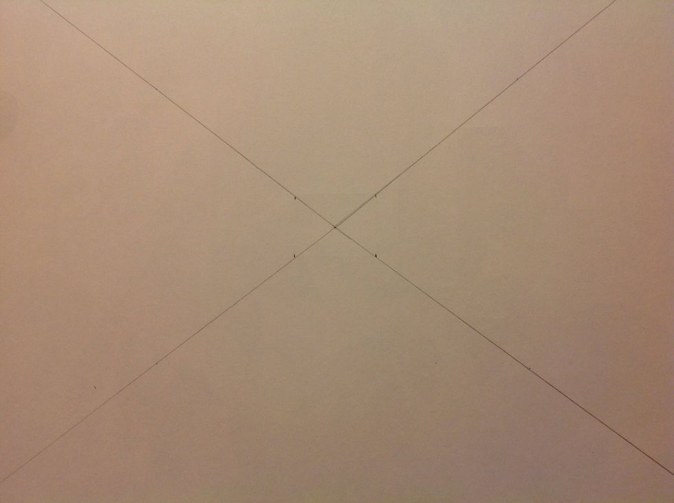 From the center point, measure out to 1 inch on the diagonal lines and make a dot on each line. You can choose your own measurement based on the size of your paper or the image you are drawing.