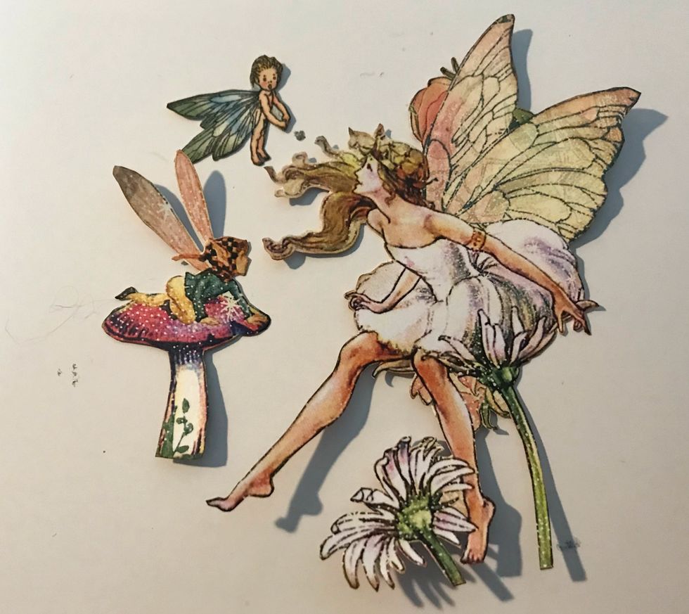 From the Dreamland paper, fussy cut out the large fairy, a small fairy and a fairy on a toadstool. Ink the edges of the images using Vintage Photo Distress Ink.