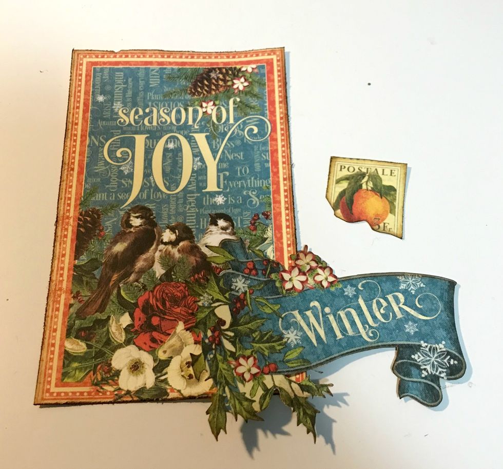 From the Ephemera cards, cut the Season of Joy card to 3 1/4" x 5 1/4". Distress the edges. Fussy cut the "winter" & stamp out of the 3"x4" card. Ink edges of all the pieces using Dark Cashmere Ink.