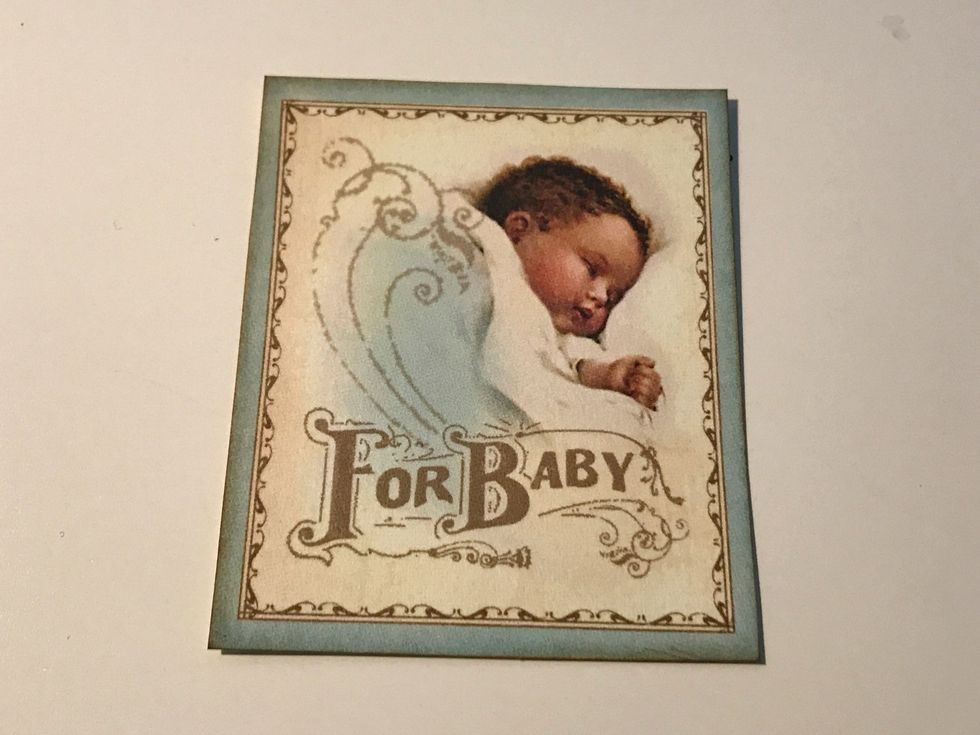 From the image paper, cut a baby square that measures 2 1/2" x 3". Ink the edges of the images using Vintage Photo Distress Ink and a blending tool with foam.
