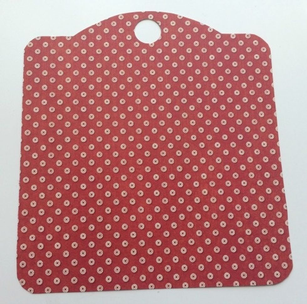 From the leftover September Montage paper, trace the kraft tag onto the red and white dot paper. Make sure to mark where the eyelet is and then punch out the hole with a 1/2" circle punch.