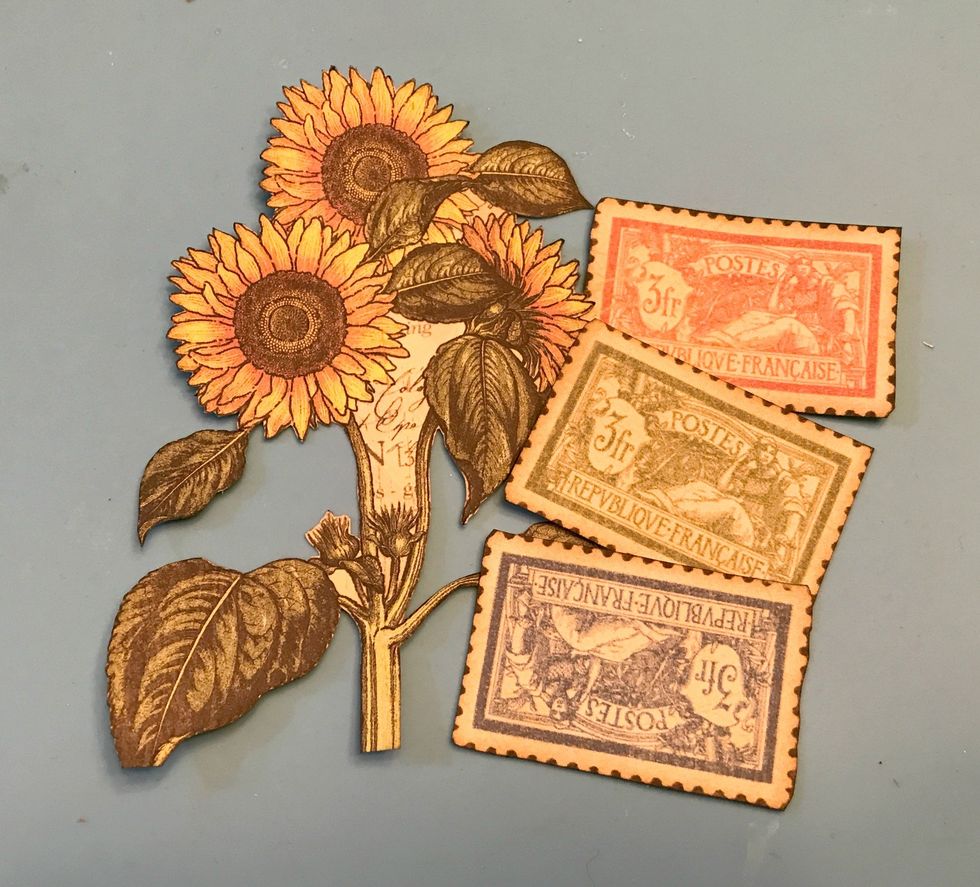 From the paper with the large rooster on it, fussy cut three postage stamps and the sunflower bunch. Ink the edges of all four pieces using Black Soot Ink and a Blending Tool with foam.