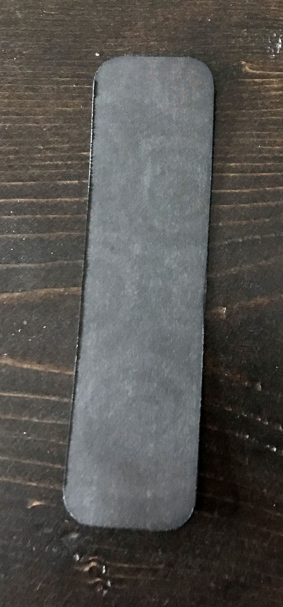 From the Patterns & Solids pack, cut a piece of the black cardstock to 1 1/4" x 4 5/8". Round all four corners. Distress the edges. Ink the edges with black ink.