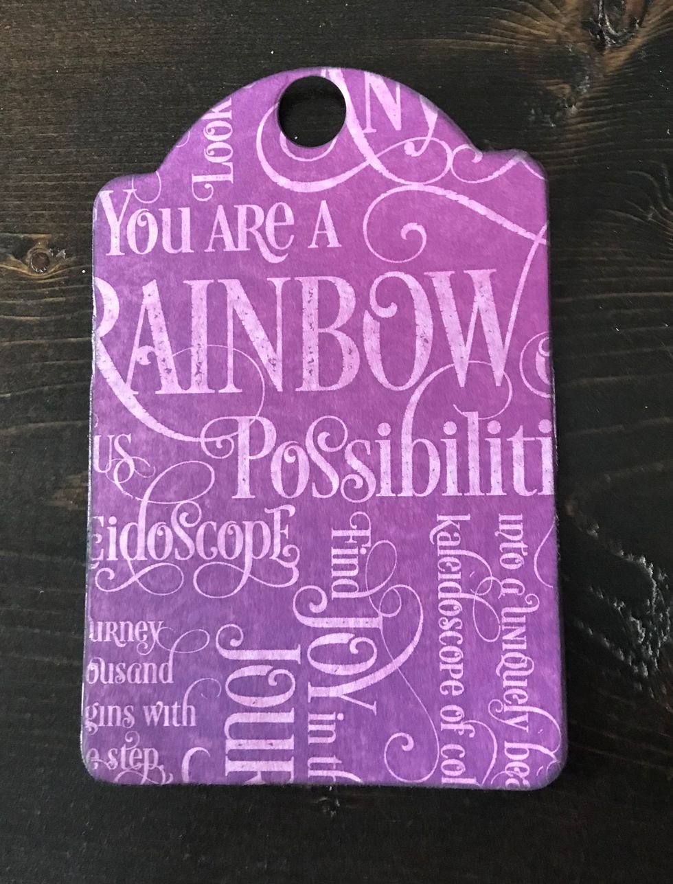 From the Patterns & Solids, take out a purple cardstock piece. Die cut the Regular Tag die out of the paper. Distress the edges. Ink the edges with black ink.