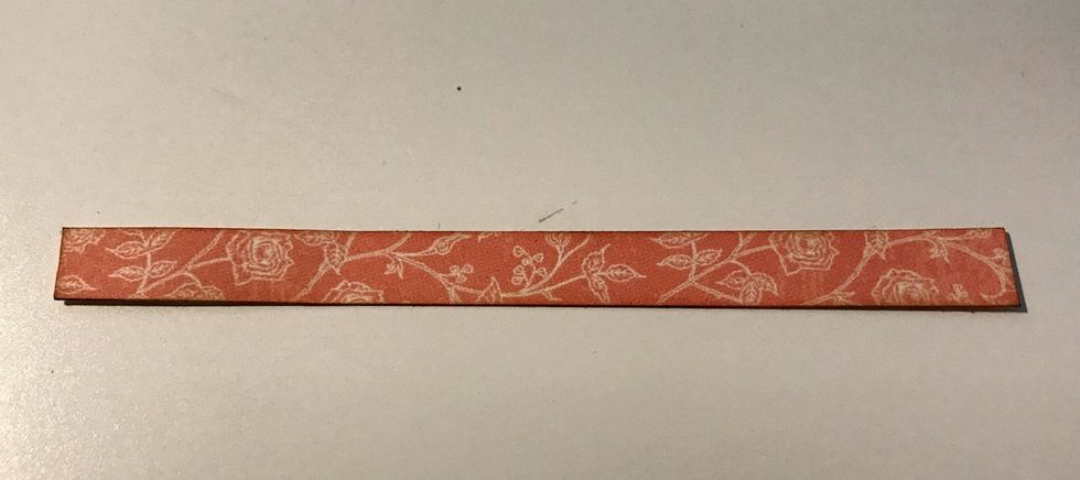 From the pink and cream floral paper, cut a piece that measures 3/8" x 4 1/4". Ink the edges of the paper using Vintage Photo Distress Ink and a Blending Tool with foam.