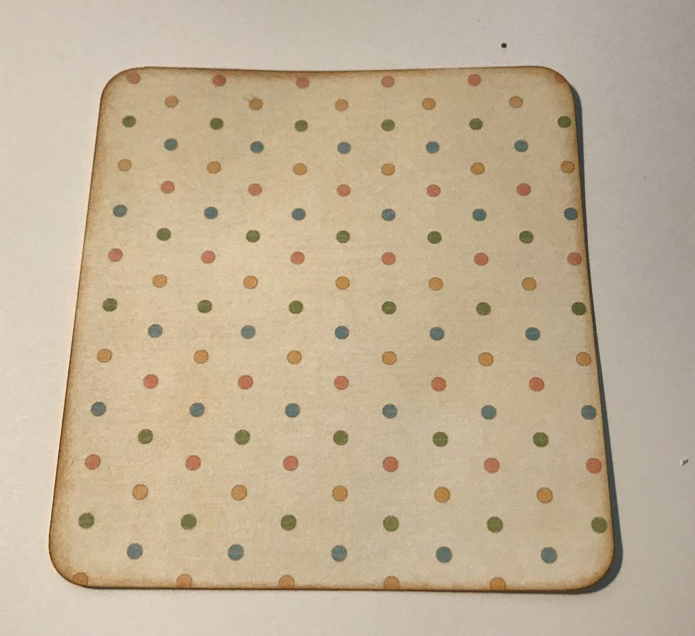 From the polka dot paper, cut a piece that measures 4" x 3 3/4". Round the corners. Ink the edges of the paper using Vintage Photo Distress Ink and a Blending Tool with foam.