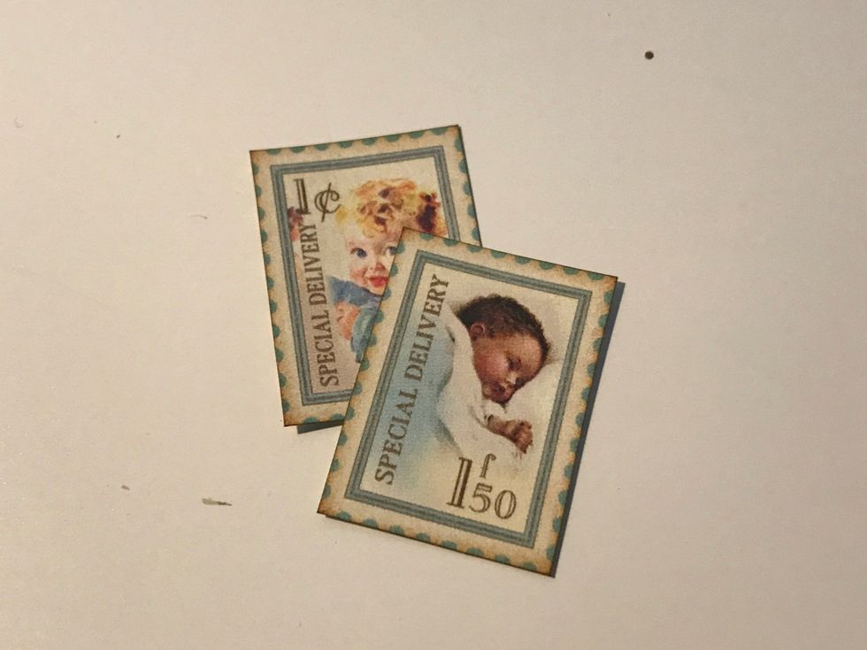 From the postage stamp paper, cut two stamps out. Ink the edges of the paper using Vintage Photo Distress Ink and a blending tool with foam.