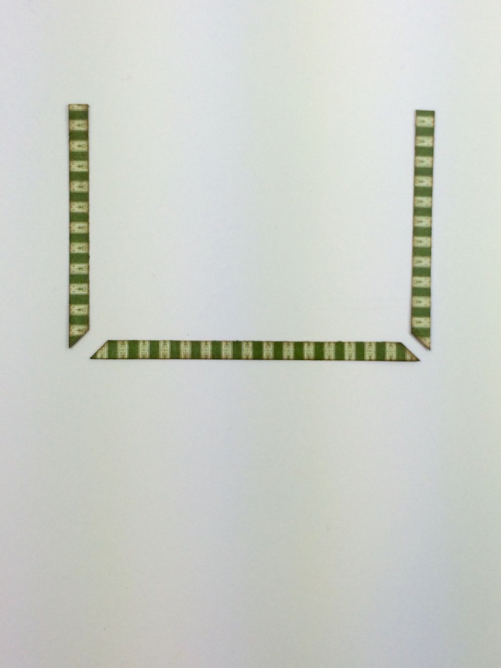 From the same stripe paper, cut two 1/4" x 3 3/8" strips and one 1/4" x 4 5/8" strip. These will go on the base of your box. Snip the corners (mitered) as shown.