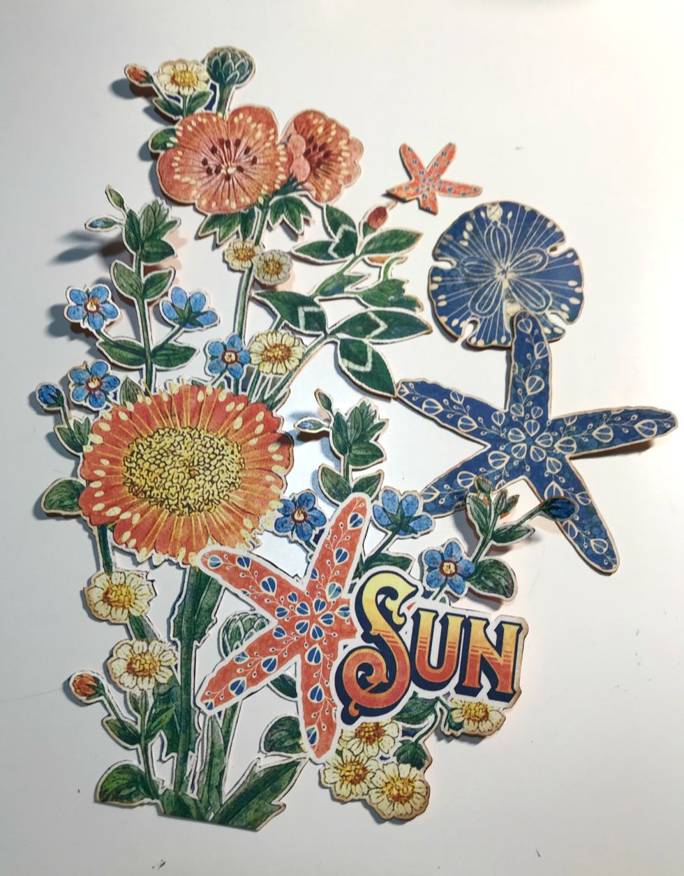 From the Sun Kissed paper, fussy cut the flower bunch, 2 starfish and 1 sand dollar. Ink the edges of the images using Vintage Photo Distress Ink and a blending tool with foam.
