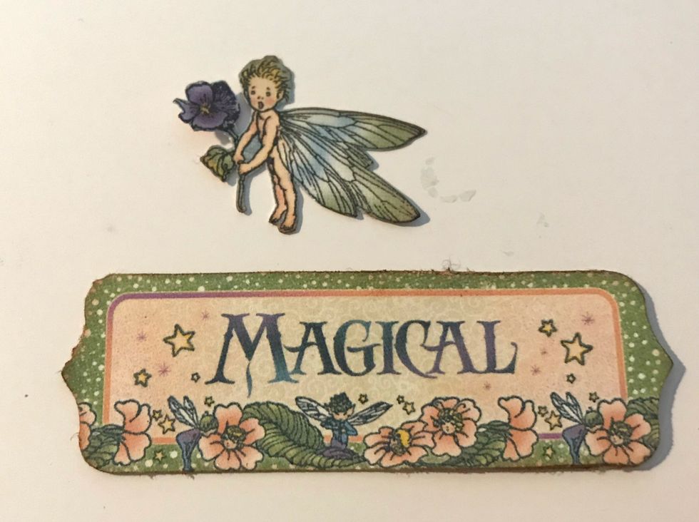 From the Tags & Pockets, punch out the Magical tag and fussy cut the small fairy from one of the other small tags.