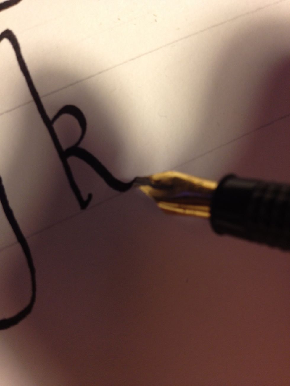 From there, go right into the third stroke, a slightly curved downward diagonal movement. Flare up at the very end to complete "k" with a thin line.