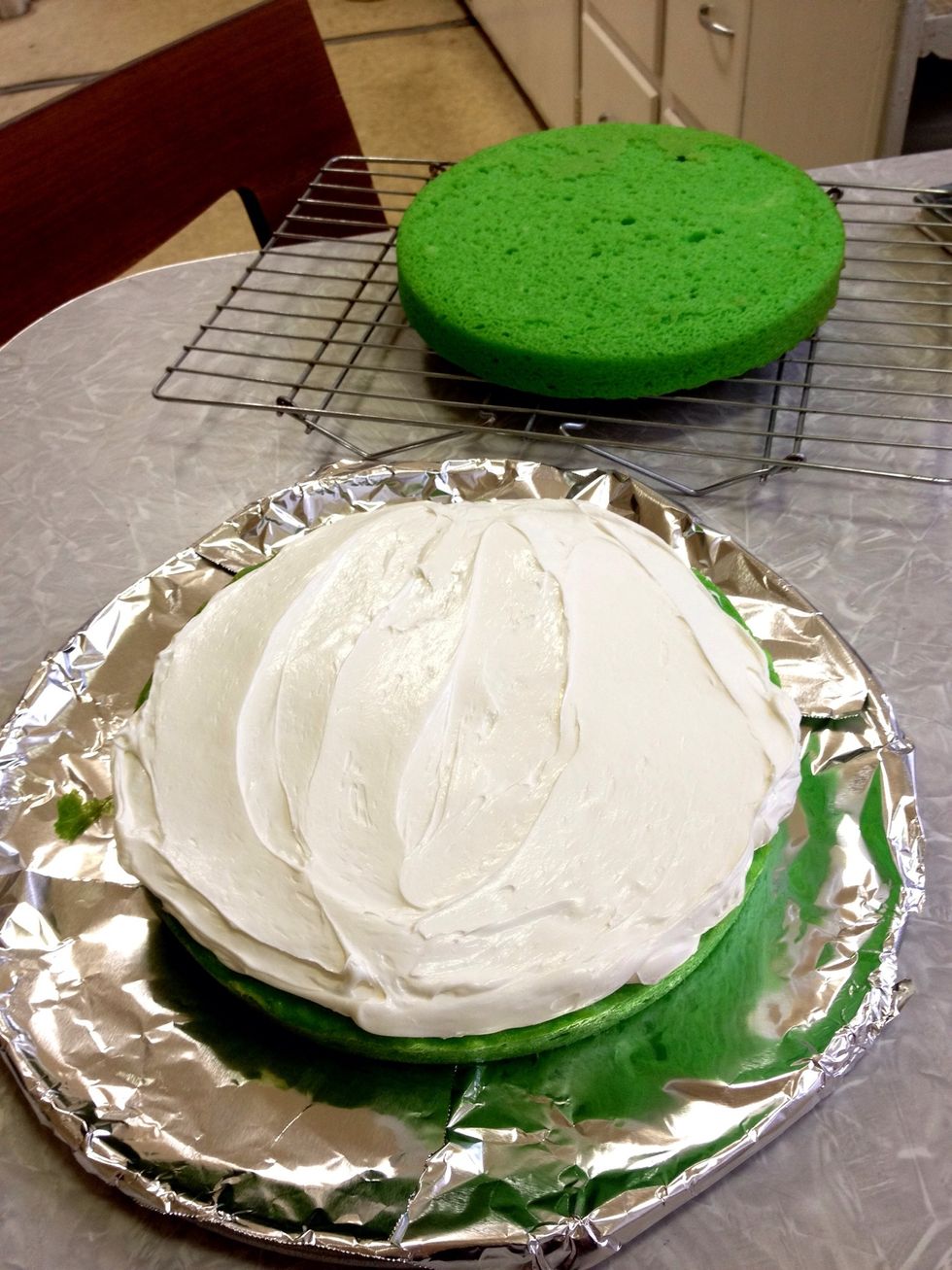 Frost the middle. I put four strips of foil to form a square underneath the cake so I don't have to worry about being neat. Just pull the strips out after icing the cake. \ud83d\udc4d