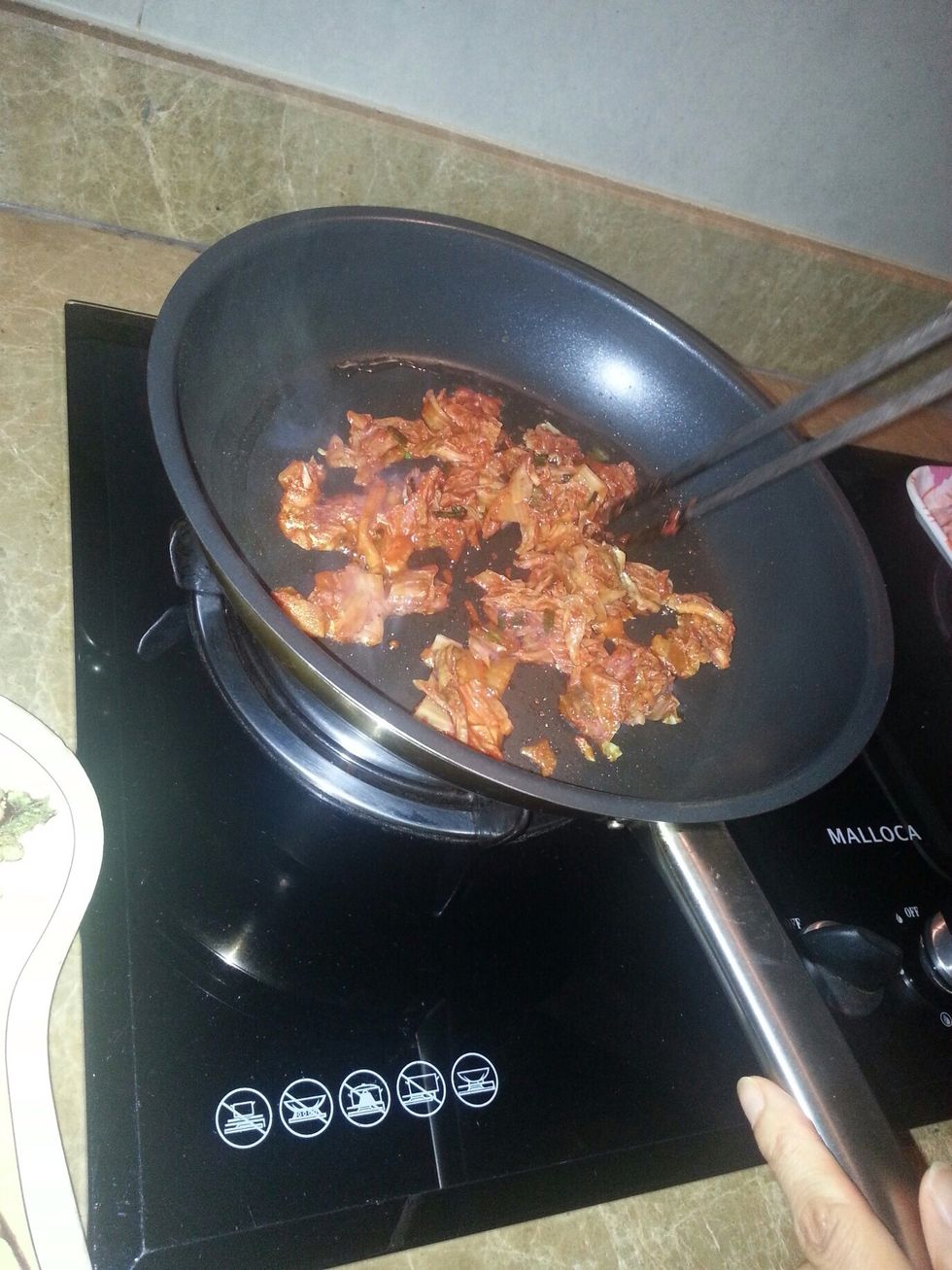 Fry the kimchi by using the chopsticks.