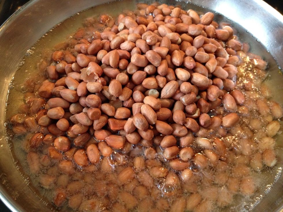 Fry the peanuts next. The peanuts will start popping and it will sometimes spit hot oil so be very careful.