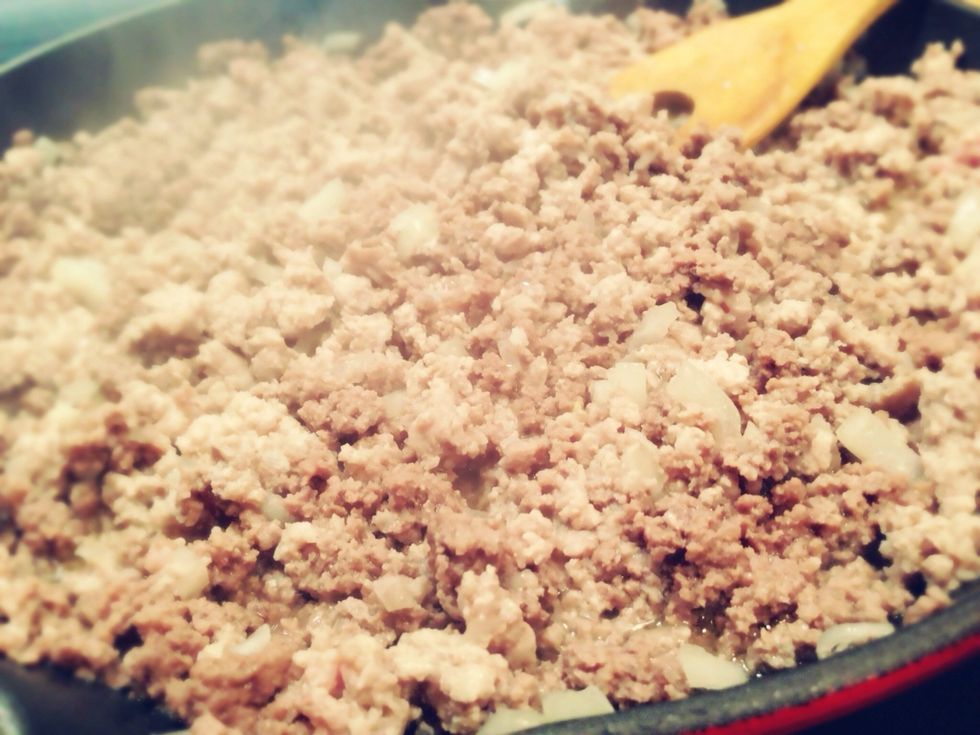 Fry two pounds ground beef and 1/2 a medium onion in a skillet until brown. Then drain.