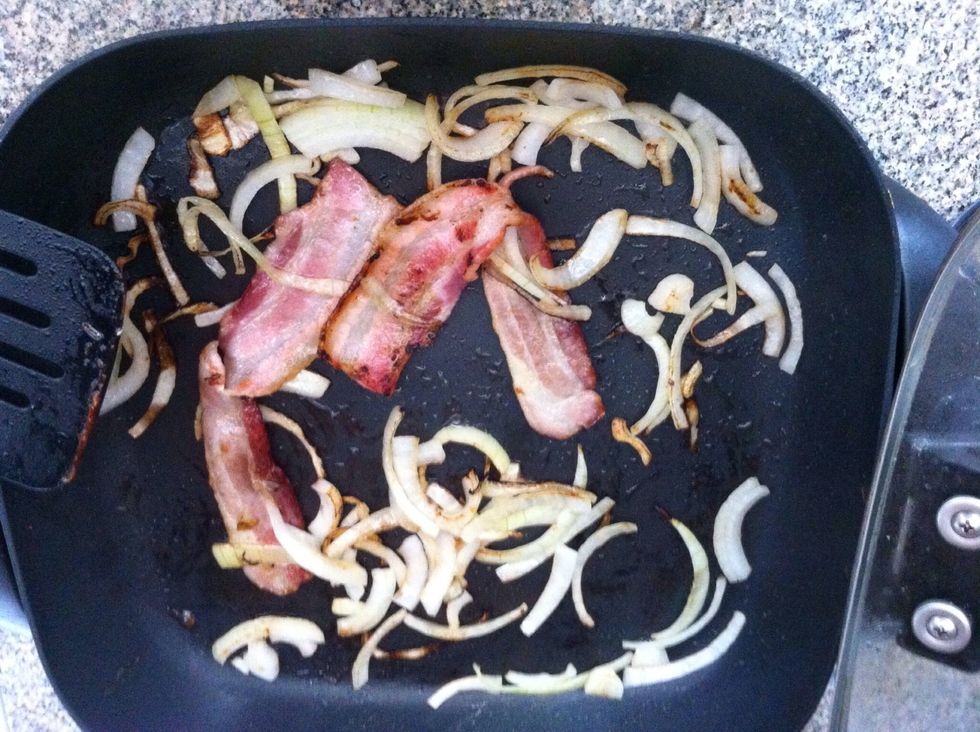 Fry your bacon in a skillet. Toss in your sliced onions, and cook them until they are golden.